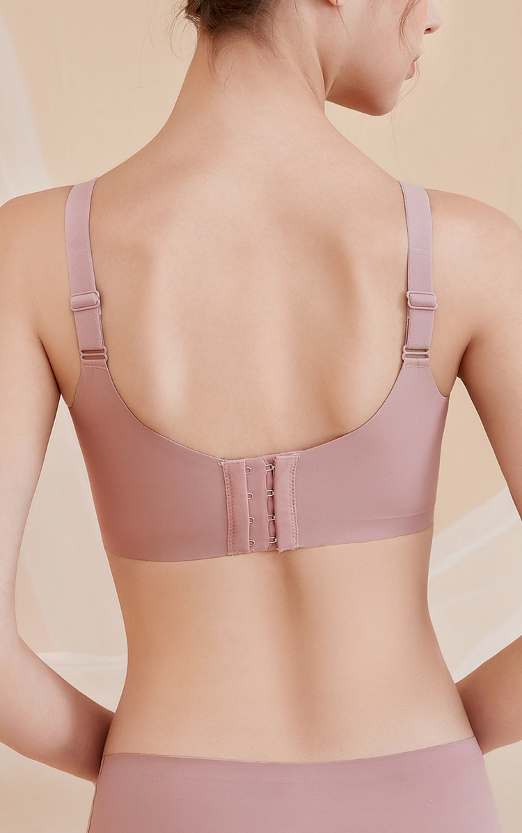 Back view of a woman wearing a pink lace molded cup bra, showcasing the wide sidebands for back smoothing and extra support.
