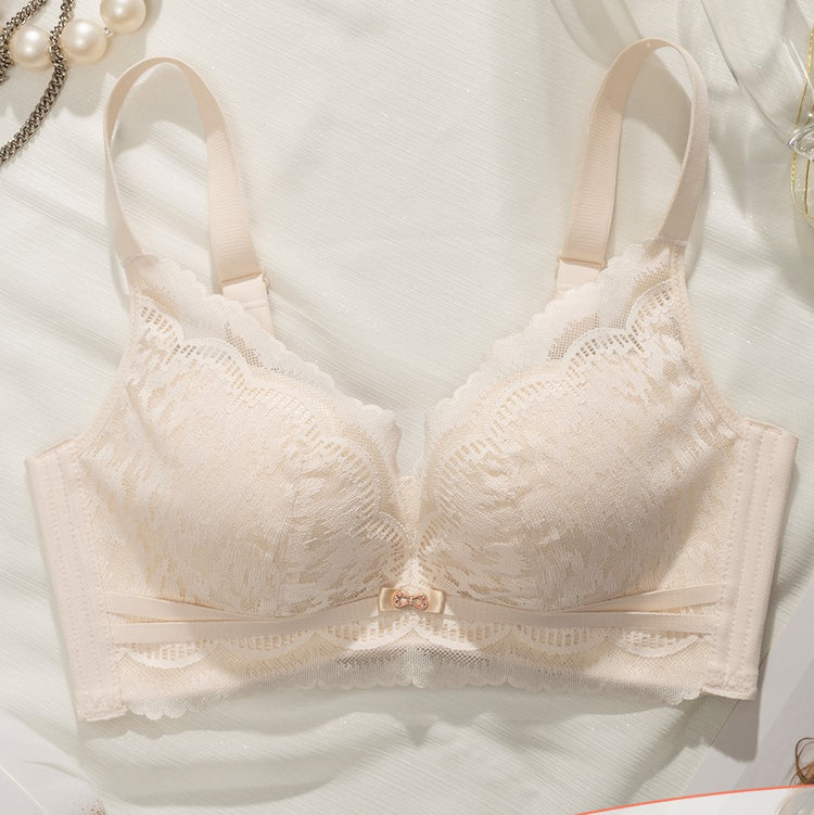 Flat lay of a white Chic Lace Wireless Push-up Bra, featuring elegant lace detailing and a small center bow, placed on a light fabric background with decorative pearls.