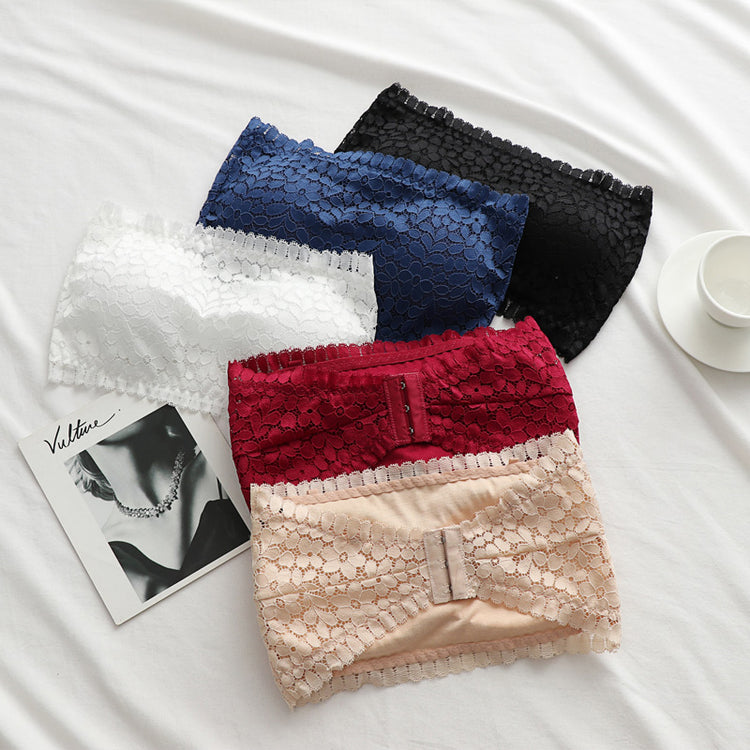 Five lace wireless tube top bras in various colors (blue, black, white, red, and beige) arranged neatly on a white surface with a magazine and cup for decoration.