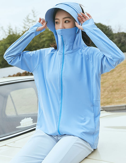 Woman in a blue sun-protection jacket with hood, wearing a sun visor and face mask, sitting on a car.