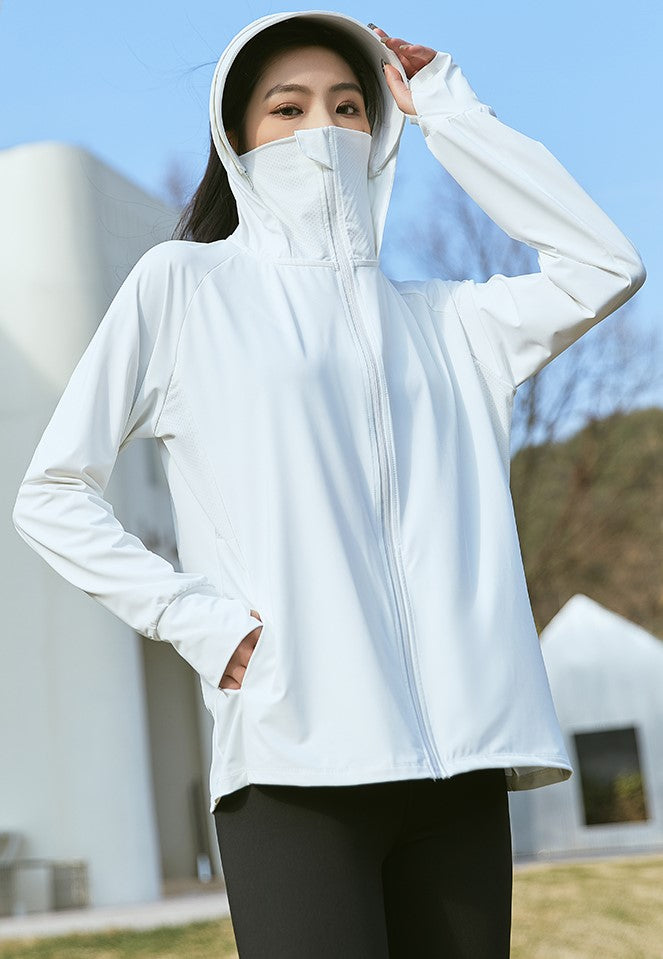 Woman wearing a white sun-protection jacket with hood and face mask, standing outdoors.